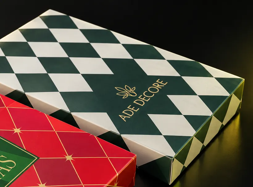 Caixa de papelcartão Ade Decore com estampa de losangos verdes e logotipo dourado